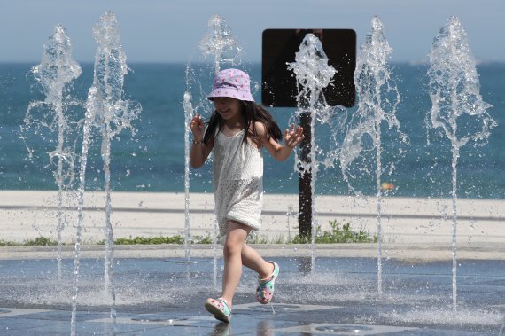 폭염주의보가 발효됐던 지난 4일 부산 해운대구 해운대해수욕장 부근 분수대에서 한 어린이가 더위를 식히고 있다.  &#x2F;사진&#x3D;뉴스1