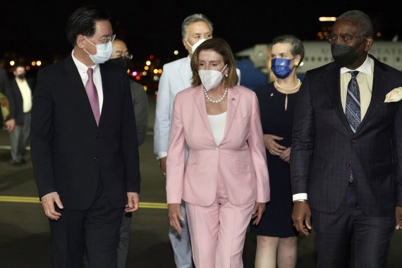 In this photo released by the Taiwan Ministry of Foreign Affairs, U.S. House Speaker Nancy Pelosi, center, walks with Taiwan&#39;s Foreign Minister Joseph Wu, left, as she arrives in Taipei, Taiwan, Tuesday, Aug. 2, 2022. Pelosi arrived in Taiwan on Tuesday night despite threats from Beijing of serious 