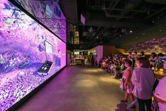 13일 일본 도쿄의 갤럭시 하라주쿠(쇼케이스)에서 소비자들이 &#39;갤럭시Z플립4 X BTS&#39; 디지털 영상을 관람하고 있다. 삼성전자 제공 