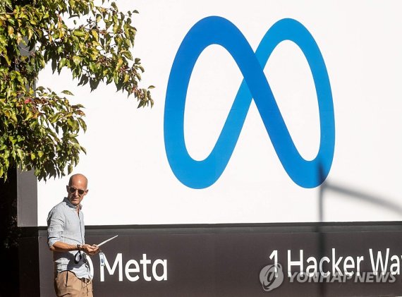 (FILES) In this file photo taken on October 28, 2021, man passes a newly unveiled logo for &quot;Meta&quot;, the new name for Facebook&#39;s parent company, outside Facebook headquarters in Menlo Park. - Meta said on September 27, 2022, it derailed a campaign out of China to influence upcoming US elections by pos