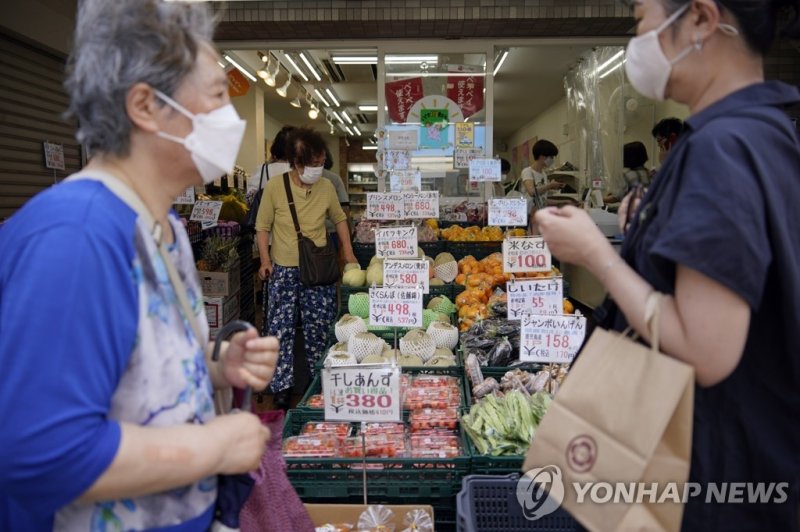 일본 도쿄 스가모구의 쇼핑가에서 행인들이 식품점 앞을 지나가고 있다. 연합뉴스