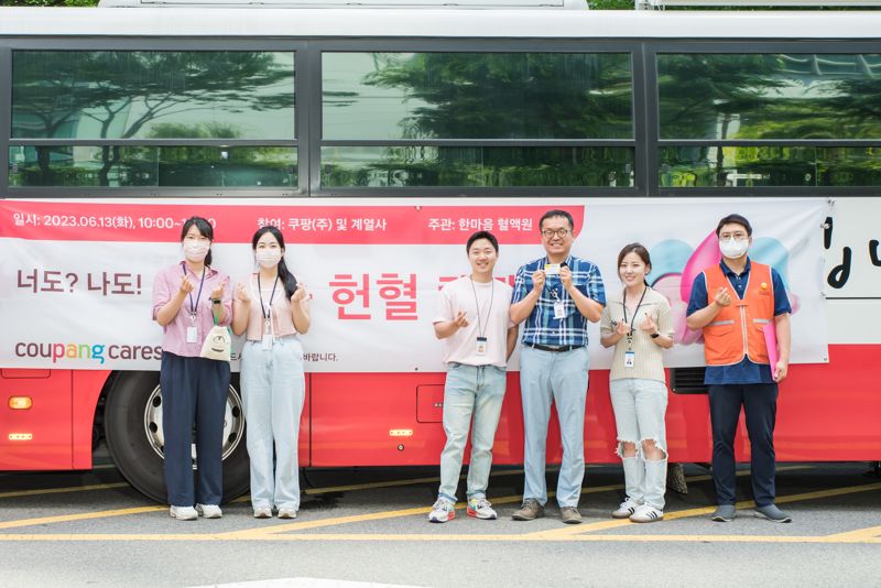 쿠팡 및 쿠팡 자회사 임직원들이 서울 잠실 사옥 주변에 마련된 헌혈버스 앞에서 기념 촬영을 하고 있다. 쿠팡 제공.