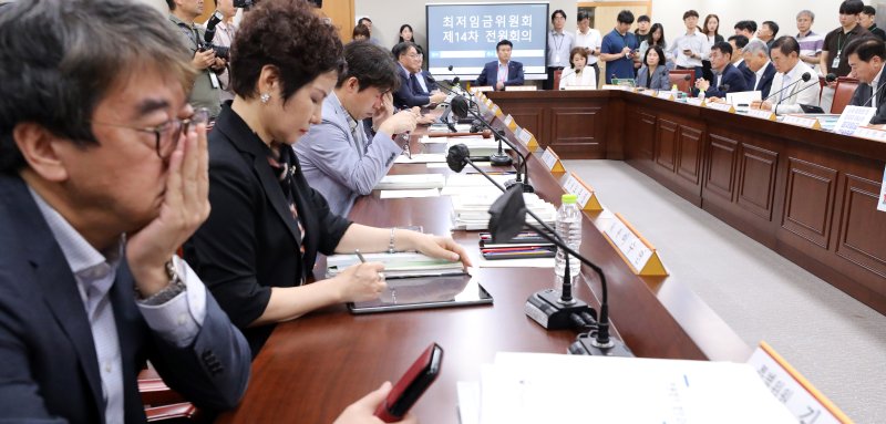 18일 세종시 정부세종청사에서 열린 최저임금위원회 14차 전원회의에서 공익위원들이 고민스런 표정으로 노사 위원들의 주장을 듣고 있다. 뉴시스