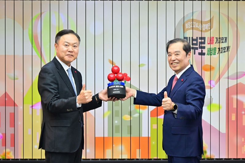 최영무 삼성사회공헌업무총괄(왼쪽)이 1일 서울 중구 사회복지공동모금회관에서 열린 연말 이웃사랑성금 전달식에서 김병준 사회복지공동모금회 회장에게 감사패를 받은 뒤 기념촬영을 하고 있다. <span id='_stock_code_005930' data-stockcode='005930'>삼성전자</span> 제공