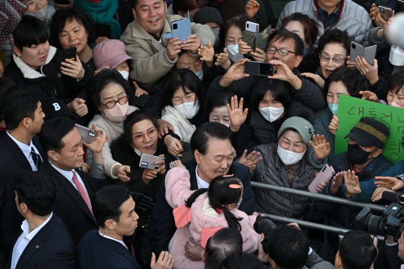 윤석열 대통령이 13일 부산 동래구 동래시장을 방문해 한 아이를 안아주고 있다. 사진=대통령실 제공
