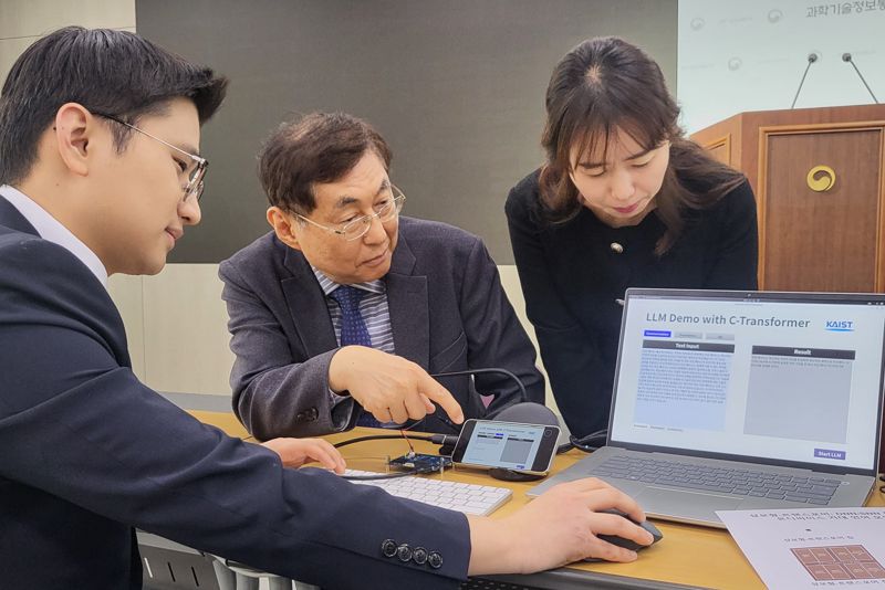 한국과학기술원(KAIST) AI반도체 대학원 유회준 교수(가운데)와 김상엽 박사가 AI 반도체 &#39;상보형-트랜스포머&#39;를 일반 노트북에 연결해 거대언어모델(LLM)인 GPT-2를 작동시키고 있다. 사진&#x3D;김만기 기자