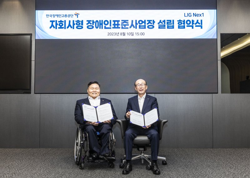 김지찬 LIG넥스원 대표이사(오른쪽)와 조향현 한국장애인고용공단 이사장이 지난해 8월 &#39;자회사형 장애인 표준사업장&#39; 설립을 위한 협약을 체결한뒤 기념촬영을 하고 있다. LIG넥스원 제공