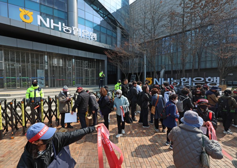 항셍중국기업지수 주가연계증권 피해자 모임 회원들이 지난 15일 오후 서울 중구 NH농협은행 앞에서 열린 &#39;대국민 금융 사기 규탄 집회&#39;에서 탄원서를 작성하고 있다. 사진&#x3D;뉴시스