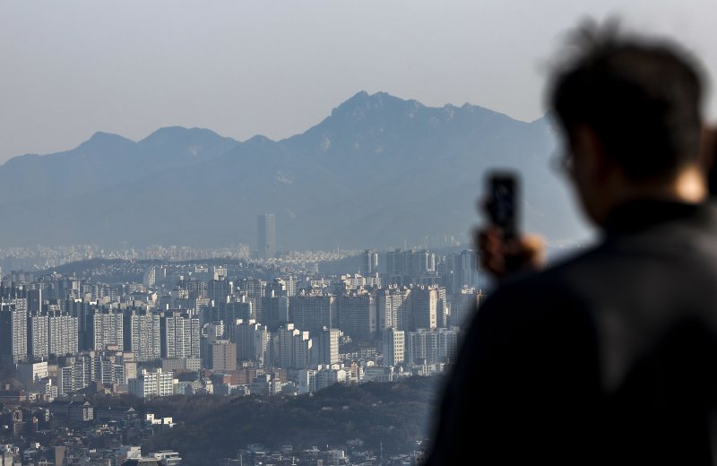지난 2일 서울 중구 남산 전망대를 찾은 시민이 서울시내 아파트를 바라보고 있다. 자료사진=뉴시스
