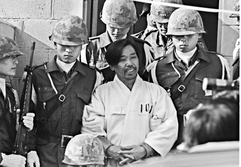 박정희 대통령 시해사건 관련자 김재규(전 중앙정보부장) 피고인이 1979년 12월 20일 육군본부 계엄 보통군법회의에서 선고공판을 받기 위해 포승에 묶여 걸어오며 웃고 있다. &#x2F;사진&#x3D;뉴시스