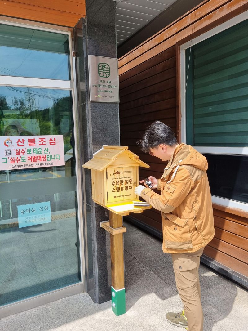 경남 거창의 금원산생태수목원을 방문한 관람객이 수목원·정원 스탬프 투어에 참여해 스탬프를 찍고 있다.