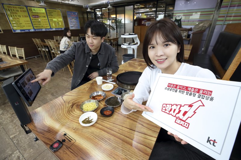 <span id='_stock_code_030200' data-stockcode='030200'>KT</span> 모델이 서울 종로구의 한 음식점에서 KT 으랏차차 패키지에 포함된 하이오더와 AI 서빙로봇을 소개하고 있다. KT 제공