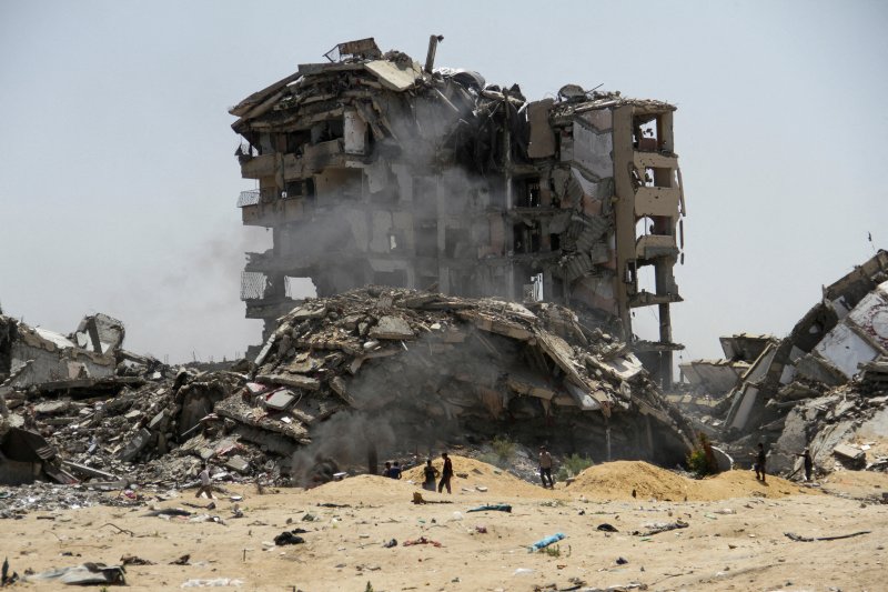 지난 22일(현지시간) 가자 북부에 이스라엘군의 공격으로 파괴된 건물 잔해 주변을 팔레스타인인들이 지나가고 있다.로이터연합뉴스