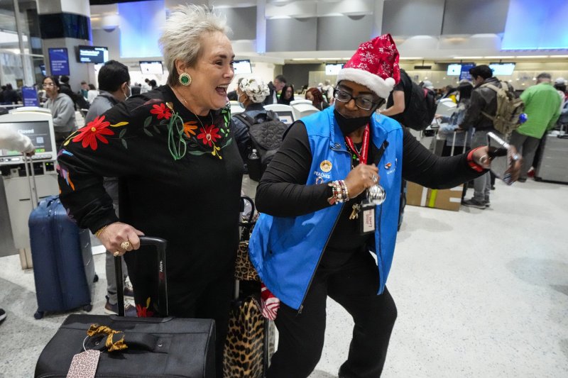 지난해 12월21일(현지시간) 미국 텍사스주 휴스턴의 조지 부시 국제공항에서 한 승객이 탑승 수속을 앞두고 항공사 직원의 안내를 받으며 즐거워하고 있다.AP뉴시스