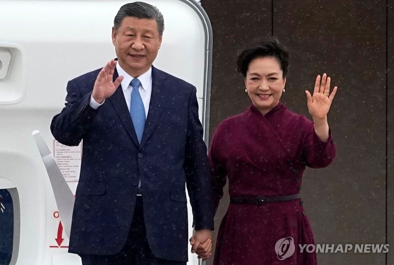 5일(현지시간) 프랑스 파리에 도착한 시진핑 중국 국가주석과 부인 펑리위안 여사가 환영객들에게 손을 흔들고 있다. AFP연합뉴스