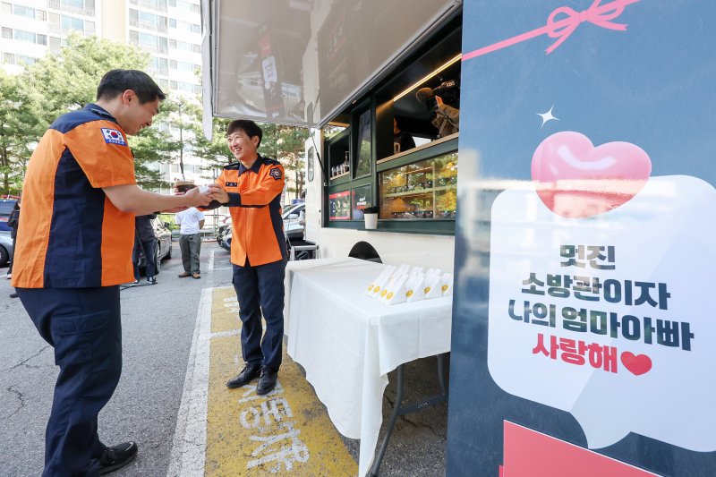 박건기 소방위가 8일 오전 서울 동작소방서에서 고3 딸 지안 양이 어버이 날을 맞아 보낸 커피차를 선물 받고 동료들에게 커피와 샌드위치를 나눠주고 있다.  &#x2F;사진&#x3D;뉴스1