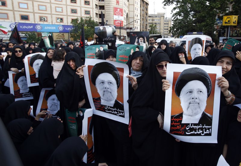 이란 수도 테헤란에서 20일(현지시간) 여성들이 헬기 추락 사고로 서거한 에브라힘 라이시 대통령 초상을 들고 애도하고 있다. 라이시 대통령 사망, 사우디아라비아 살만 국왕 건강 이상 등 중동 지역 불안에도 불구하고 이날 국제 유가는 초반 상승세를 딛고 하락세로 돌아섰다. EPA 연합