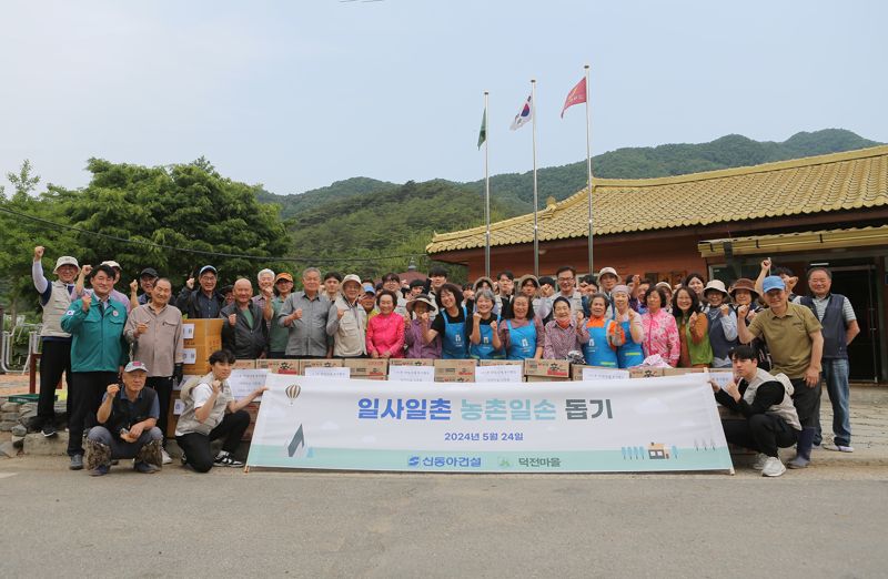 지난 24일 강원 영월군 덕전마을에서 신동아건설 임직원들이 마을주민들과 함께 기념촬영을 하고 있다. 신동아건설 제공