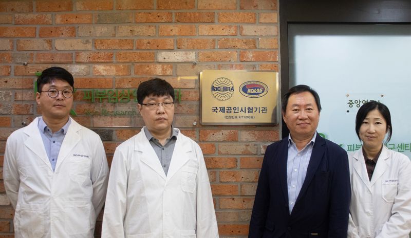 이해광 <span id='_stock_code_347740' data-stockcode='347740'>피엔케이피부임상연구센타</span> 대표(오른쪽 두번째)와 직원들이 지난 3일 서울 여의도 본사에서 한국인정기구 국제공인시험기관 인정 현판식을 진행한 뒤 기념 촬영하고 있다. 피엔케이피부임상연구센타 제공