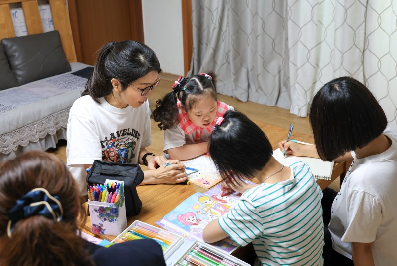 윤석열 대통령 부인 김건희 여사가 추석 명절 연휴인 15일 서울 은평구 다움장애아동지원센터를 찾아 어린이들의 밑그림을 도와주고 있다. (사진&#x3D;대통령실 제공) &#x2F;사진&#x3D;뉴시스화상