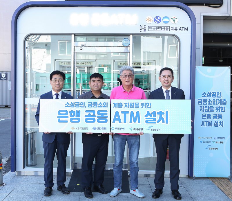 지난달 30일 강원도 삼척중앙시장에서 열린 은행 공 ATM 설치 행사에서 박규상 <span id='_stock_code_063570' data-stockcode='063570'>한국전자금융</span> 전무이사(왼쪽 첫 번째), 김종한 삼척시청 경제과장(왼쪽 두 번째), 정종광 삼척중앙시장 상인회장(왼쪽 세 번째), 이인균 은행연합회 본부장이 기념촬영을 하고 있다. 은행연합회 제공