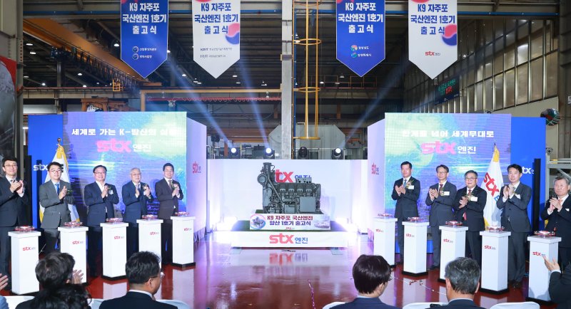 박성택 산업통상자원부 1차관이 27일 경남 <span id='_stock_code_011810' data-stockcode='011810'>STX</span> 창원공장에서 열린 K9 자주포 국산 1호 엔진 출고식에서 참석자들과 기념촬영을 하고 있다./뉴시스