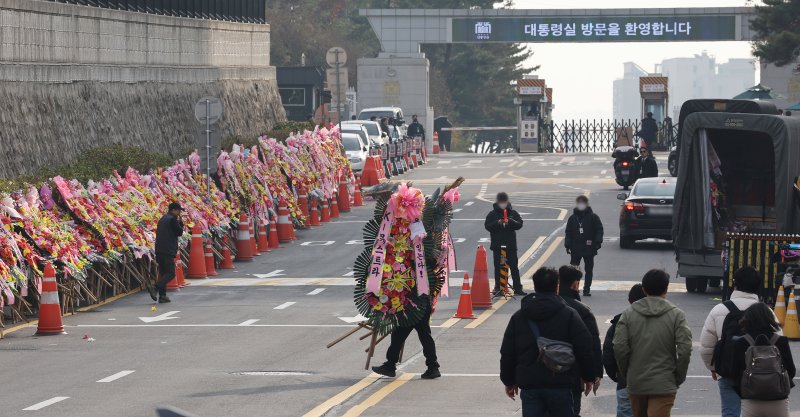 11일 오후 서울 용산구 대통령실 출입문 앞 도로에서 화환 업체 관계자가 윤석열 대통령 지지자들이 보낸 화환을 옮기고 있다. &#x2F;사진&#x3D;뉴스1