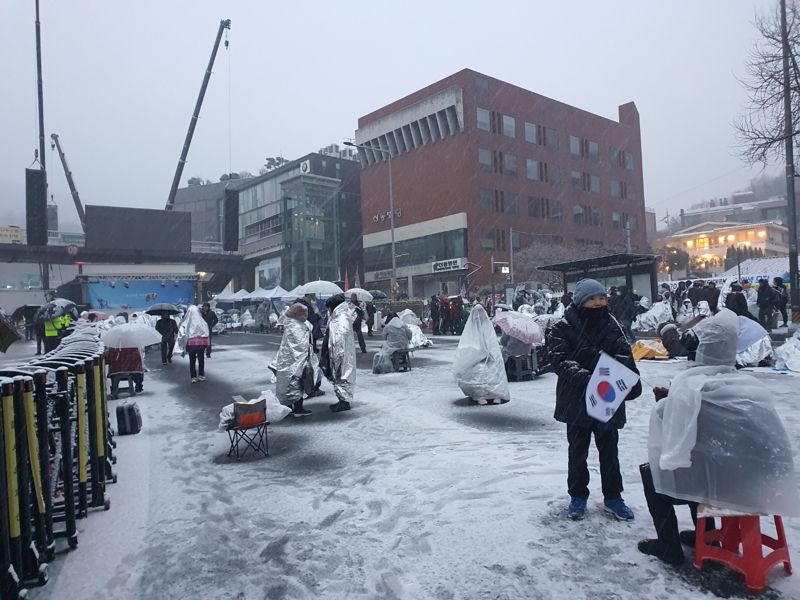 용산구 루터 교회 앞 폭설 속에서 삼삼오오 모여 의견을 나누는 반대집회 참가자들 모습. 사진&#x3D;최승한 기자