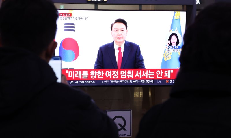 윤석열 대통령의 탄핵소추안이 국회에서 가결된 지난해 12월 14일 오후 서울역에서 시민들이 윤석열 대통령의 대국민 담화를 TV를 통해 지켜보고 있다. 연합뉴스