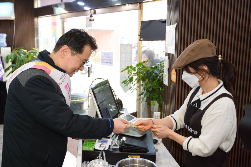 부산형 착한결제 캠페인에 참여한 박동호 화승네트웍스 대표(왼쪽)가 식당에서 선결제를 하고 있다. 부산시 제공 