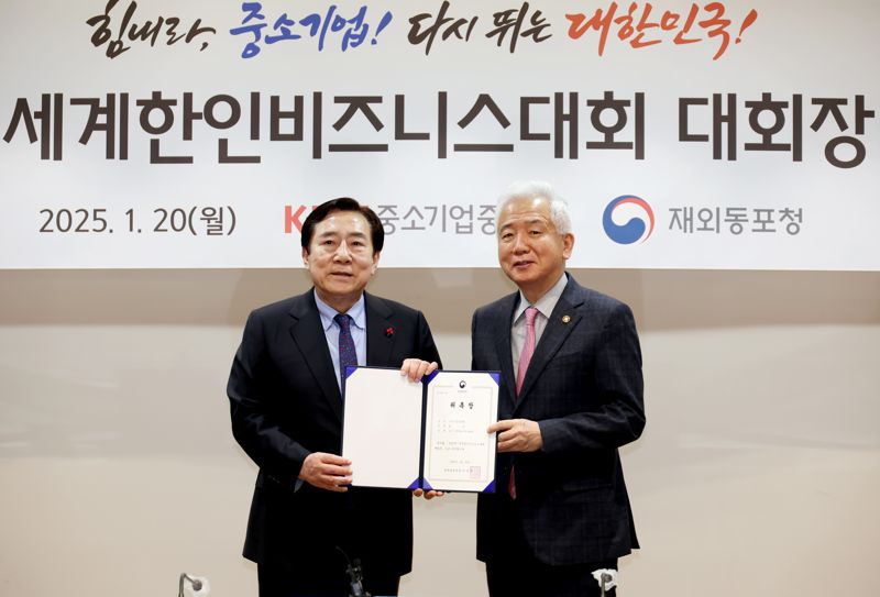 김기문 중소기업중앙회장(왼쪽)이 20일 서울 여의도 중소기업중앙회에서 이상덕 재외동포청장으로부터 ‘제23차 세계한인비즈니스대회’ 대회장 위촉장을 받은 뒤 기념 촬영을 하고 있다. 중소기업중앙회 제공