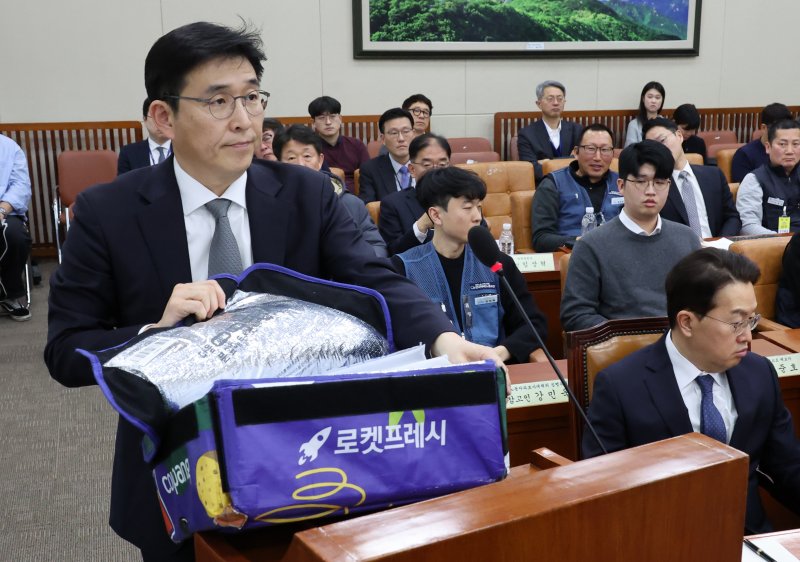 [서울&#x3D;뉴시스] 조성우 기자 &#x3D; 홍용준 쿠팡로지스틱스서비스(CLS) 대표가 21일 서울 여의도 국회에서 열린 환경노동위원회의 쿠팡 택배노동자 심야노동 등 근로조건 개선을 위한 청문회에서 강득구 더불어민주당 의원이 준비한 프레시백을 펼쳐 보이고 있다. 오른쪽은 강한승 쿠팡 태표. 2025.01.21. xconfind@newsis.com &lt;저작권자ⓒ 공감언론 뉴시스통신사. 무단전재-재배포 금지.&gt; &#x2F;사진&#x3D;뉴시스화상