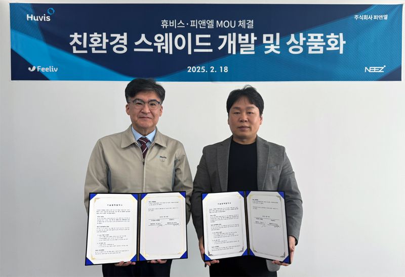 박성윤 휴비스 연구소장(왼쪽)과 이경수 피앤엘 대표이사가 지난 18일 휴비스 대전연구소에서 진행된 업무협약 체결식에서 기념사진을 촬영하고 있다. 휴비스 제공