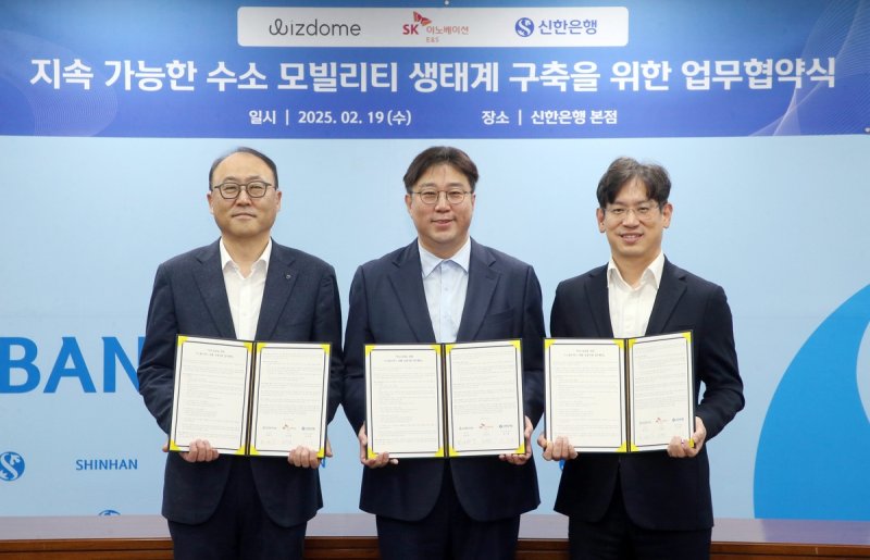 19일 서울시 중구 신한은행 본점에서 ‘수소 모빌리티 생태계 구축’을 위한 업무협약을 체결하고 신한은행 영업추진2그룹 김기흥 부행장(왼쪽), 위즈돔 한상우 대표이사(가운데), <span id='_stock_code_096770' data-stockcode='096770'>SK이노베이션</span> E&amp;S 수소마케팅실 소유섭 부사장이 기념 촬영을 하고 있다. 신한은행 제공 