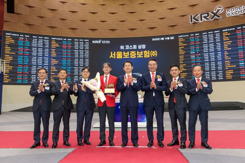 14일 오전 서울 여의도 한국거래소에서 열린 서울보증보험 유가증권시장 신규상장식에서 이명순 서울보증보험 대표이사(왼쪽에서 4번째)와 관계자들이 기념 촬영을 하고 있다. 사진=서울보증보험 제공 
