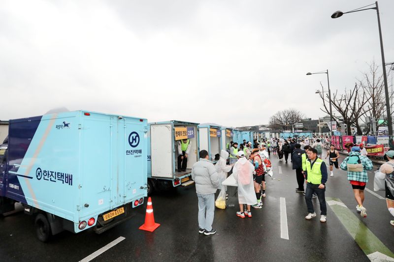 16일 오전 2025 서울마라톤 공식 물류사로 참여한 한진택배 차량들이 광화문 광장에서 대회 참가자들의 물품을 수거하고 있다.
