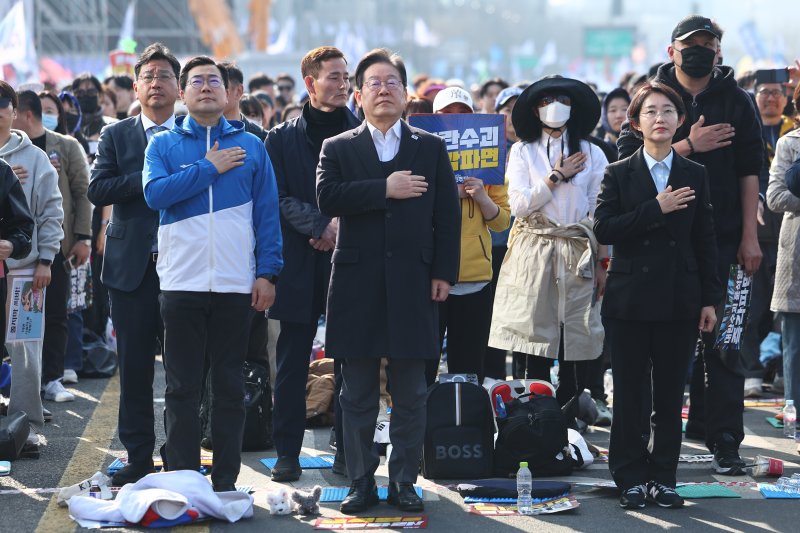 더불어민주당 이재명 대표와 박찬대 원내대표가 22일 서울 종로구 동십자각 앞에서 열린 야5당 공동 비상시국 범국민대회에서 국민의례를 하고 있다. 연합뉴스