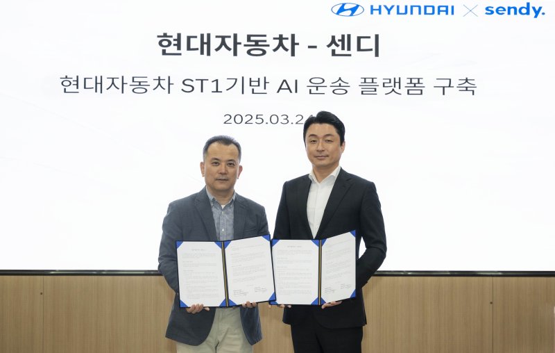 오기용 현대자동차 국내SV사업실 상무(왼쪽), 염상준 센디 대표이사가 지난 24일 서울 강남 <span id='_stock_code_005380' data-stockcode='005380'>현대차</span> 사옥에서 'ST1 기반 인공지능(AI) 운송 플랫폼 구축을 위한 업무협약'(MOU) 체결 후 기념촬영하고 있다. 현대차 제공