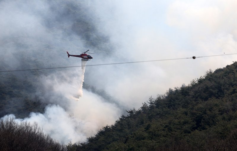 [의성=뉴시스] 이무열 기자 = 경북 의성군 산불 발생 나흘째인 25일 비안면 산제리 철파리 한 야산에서 산불진화헬기가 진화작업을 하고 있다. 2025.03.25. lmy@newsis.com /사진=뉴시스
