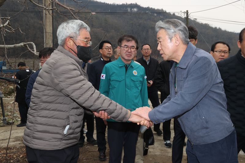 강호동 농협중앙회장(오른쪽)이 28일 경북 산불 피해현장에서 농업인의 손을 맞잡고 깊은 위로의 말씀을 전하고 있다.