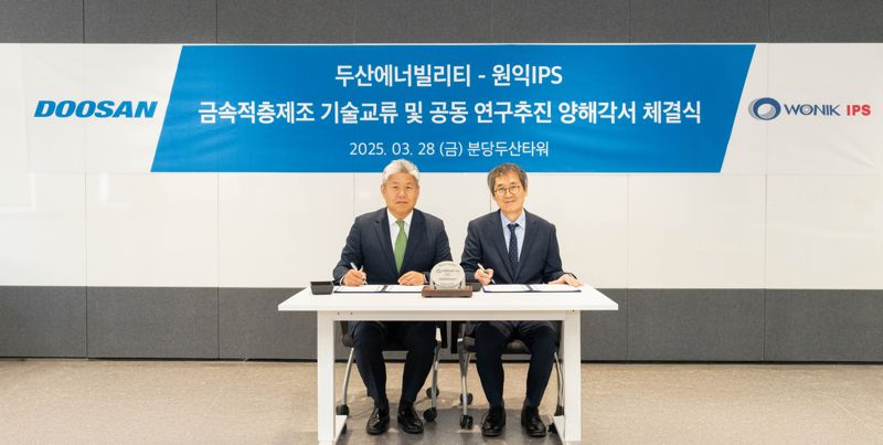 이희범 <span id='_stock_code_034020' data-stockcode='034020'>두산에너빌리티</span> 전략·혁신 담당(왼쪽)이 지난 28일 경기도 성남시 분당두산타워에서 이명범 <span id='_stock_code_240810' data-stockcode='240810'>원익IPS</span> 선행개발본부 총괄과 ‘적층제조 기술 교류 및 연구 추진’ 양해각서(MOU)를 체결하고 있다. 두산에너빌리티 제공