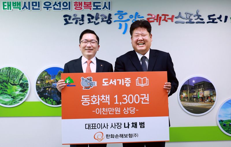 나채범 한화손해보험 대표이사(왼쪽)와 이상호 태백시장이 8일 태백시 황지동 태백시청에서 열린 '지역활성화를 위한 동화책 기증식'에서 기념촬영을 하고 있다. 한화손보 제공