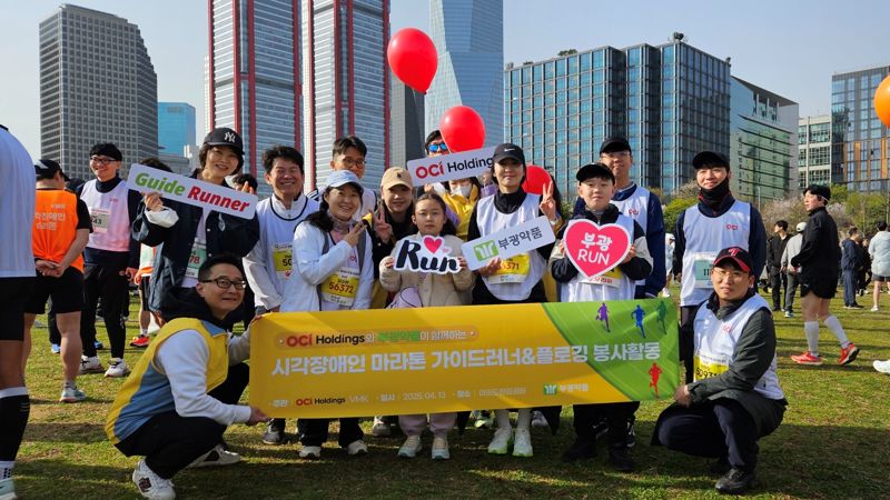 '제13회 행복한가게 마라톤대회'에 참여한 OCI홀딩스 가족 참가자들이 13일 서울 여의도한강공원에서 기념촬영을 하고 있다. OCI홀딩스 제공