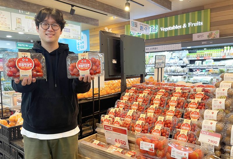 GS더프레시 과일 MD가 푸르메소셜팜에서 매입해 판매하고 있는 토마토를 들고 포즈를 취하고 있다. <span id='_stock_code_007070' data-stockcode='007070'>GS리테일</span> 제공