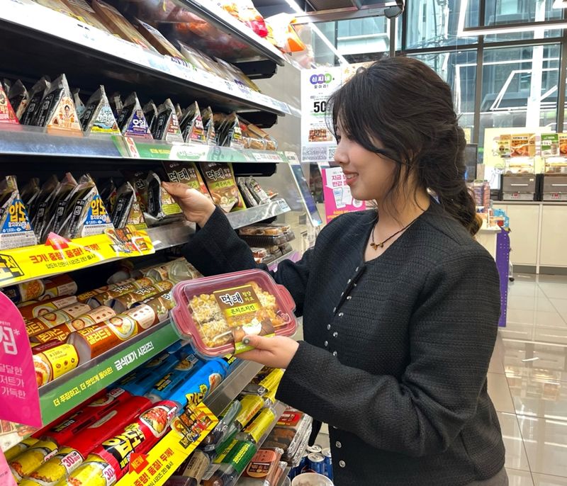 고객이 CU가 새로 출시한 먹태청양마요 만능소스를 활용한 간편식을 살펴보고 있다. CU 제공