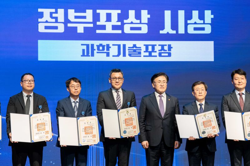 송용진 전략&middot;혁신 부문장(사장&middot;왼쪽 세번째)이 21일 서울 강남구 한국과학기술회관에서 열린 제58회 과학의 날 기념식에서 과학기술 분야 포장을 수상한 뒤 관계자들과 기념촬영을 하고 있다. <span id='_stock_code_034020' data-stockcode='034020'>두산에너빌리티</span> 제공