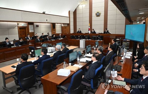 12&middot;3 비상계엄을 선포해 내란 우두머리 혐의로 재판에 넘겨진 윤석열 전 대통령이 21일 오전 서울 서초구 서울중앙지법 417호 법정에 변호인단과 함께 앉아 있다. 사진공동취재단 /사진=연합뉴스