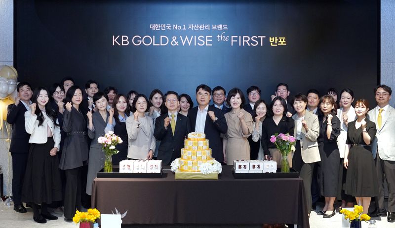 지난 22일 'KB 골드 앤 와이즈 더 퍼스트 반포' 1주년 기념행사에서 KB국민은행 정은영 상무, KB국민은행 박병곤 영업그룹 이사부행장, KB증권 이홍구 대표이사(앞줄 왼쪽 다섯번째부터)가 임직원들과 기념촬영을 하고 있다. KB금융그룹 제공