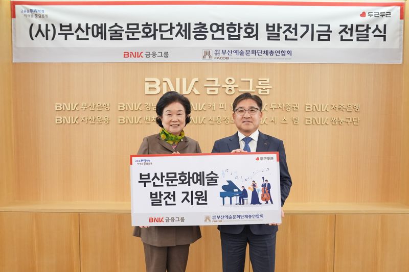 부산예총 오수연 회장과 <span id='_stock_code_138930' data-stockcode='138930'>BNK금융지주</span> 강종훈 부사장(왼쪽부터)이 문화예술 발전기금 전달식에서 기념촬영을 하고 있다. BNK금융그룹 제공