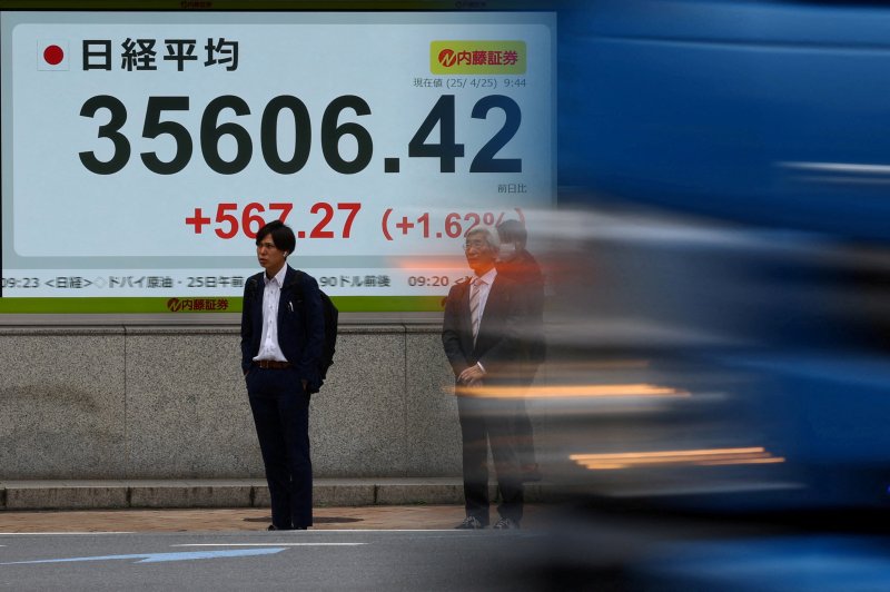 지난달 25일 일본 도쿄의 증권사 앞 횡단보도에 증시 시황판이 빛나고 있다.로이터연합뉴스